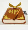 Harry Potter Theme Cake shaped like a magical spellbook with wand, golden snitch, and HP logo – perfect for wizard themed birthdays BakersStreet.in